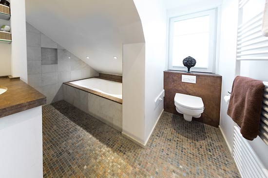 Badewanne und WC für Gäste auf engem Raum. Boden aus Copper Mosaik kombiniert mit Fliesen aus Estremos und dem Hartgestein Brown Chocolate.