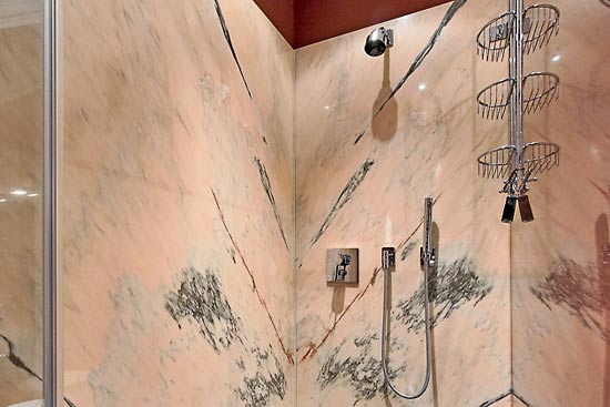 Die Wand der Dusche wurde spiegelbildlich aus einer großen Unmaßtafel des Estremos Marmors geschnitten und perfekt passend aufgebaut.
