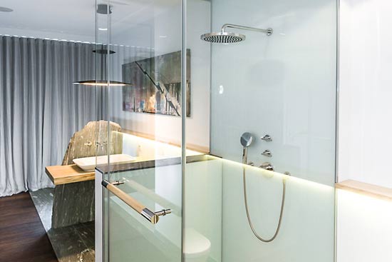 Der Duschbereich wird durch Glaswände vom Rest des Badezimmers getrennt.