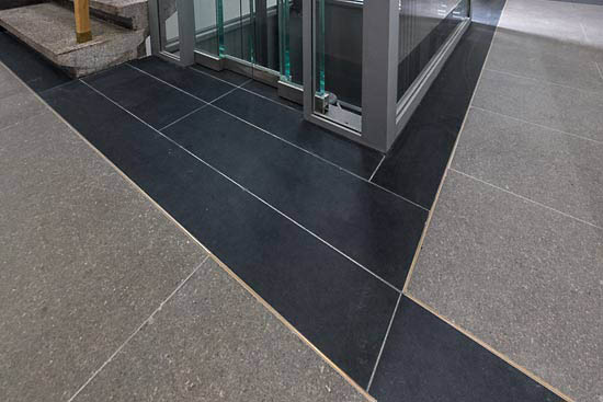Nero Assoluto – Einrahmung des Fahrstuhlschachtes. Die Bodenplatten des Fahrstuhlbodens sind in gleichem Material verlegt.
