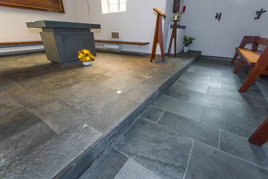 Kapelle mit Natursteinboden. In der Kapelle ist der bestehende Bodenbelag aufgearbeitet, die anschließenden Bodenplatten sind mit Alta Quarzit ergänzt.