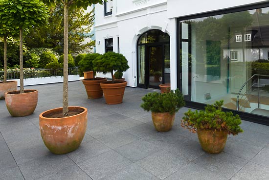 Blick auf den mit dem Naturstein Black Pearl ausgelegten schattigen Eingangsbereich einer Villa in Hamburg-Blankenese.