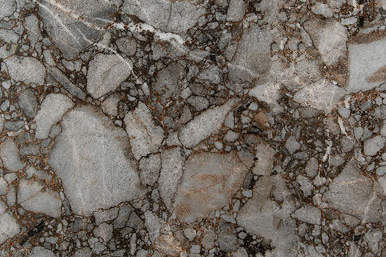 FLORIM stone Keramik Riverbed. Dieses Keramikmaterial bietet den Blick auf ein Flußbett über welches in weißen Reflexen das Wasser fließt.